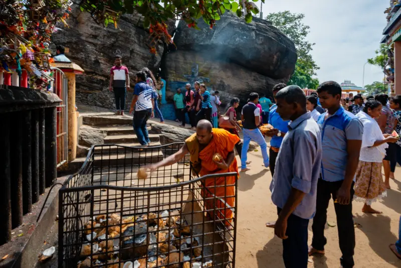 A coconut being smashed by a monk at the Koneswsaram Temple - Tricomalee, Sri Lanka