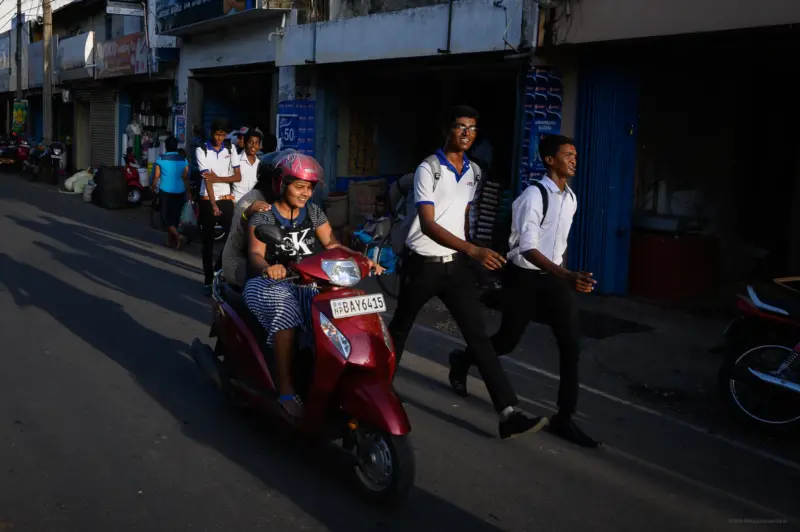 Two women on a scooter and walking school boys - Jaffna, Sri Lanka